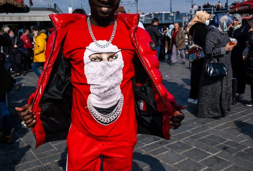 Vibrant street fashion scene with a person in a striking red outfit and chain necklace in Istebna, Poland.