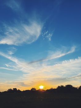 Beautiful sunset with dramatic clouds and a vibrant blue sky.