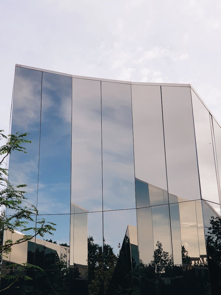 Modern Glass Geometric Building Against Sky Background