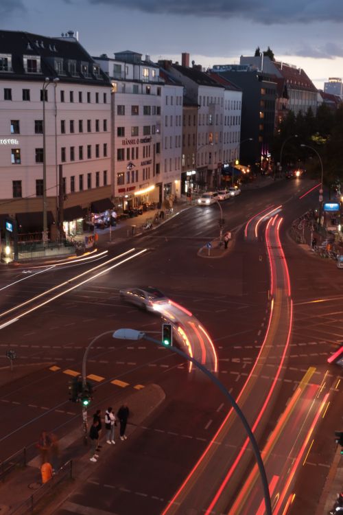 Free A vibrant Berlin intersection at night captures dynamic light trails, showcasing urban movement. Stock Photo