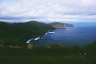 在多云的天空下，阿佐尔的海岸线与郁郁葱葱的山丘和蓝色的海水构成了一幅壮丽的景色