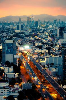 A breathtaking aerial view of Mexico City at twilight with vibrant lights and skyscrapers.