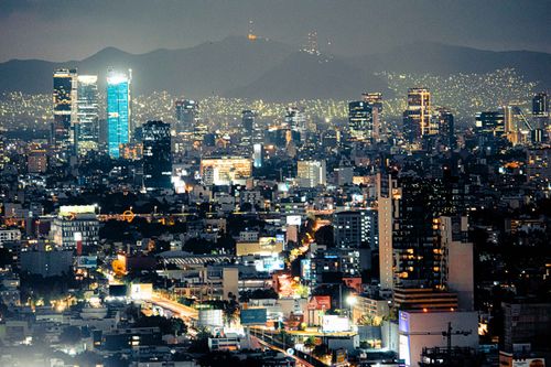 Free Stunning Mexico City skyscrapers illuminated at nightfall with an urban landscape backdrop. Stock Photo