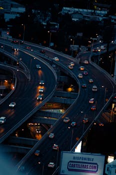 Aerial shot capturing vibrant highway traffic in Mexico City, highlighting urban transport system during twilight.