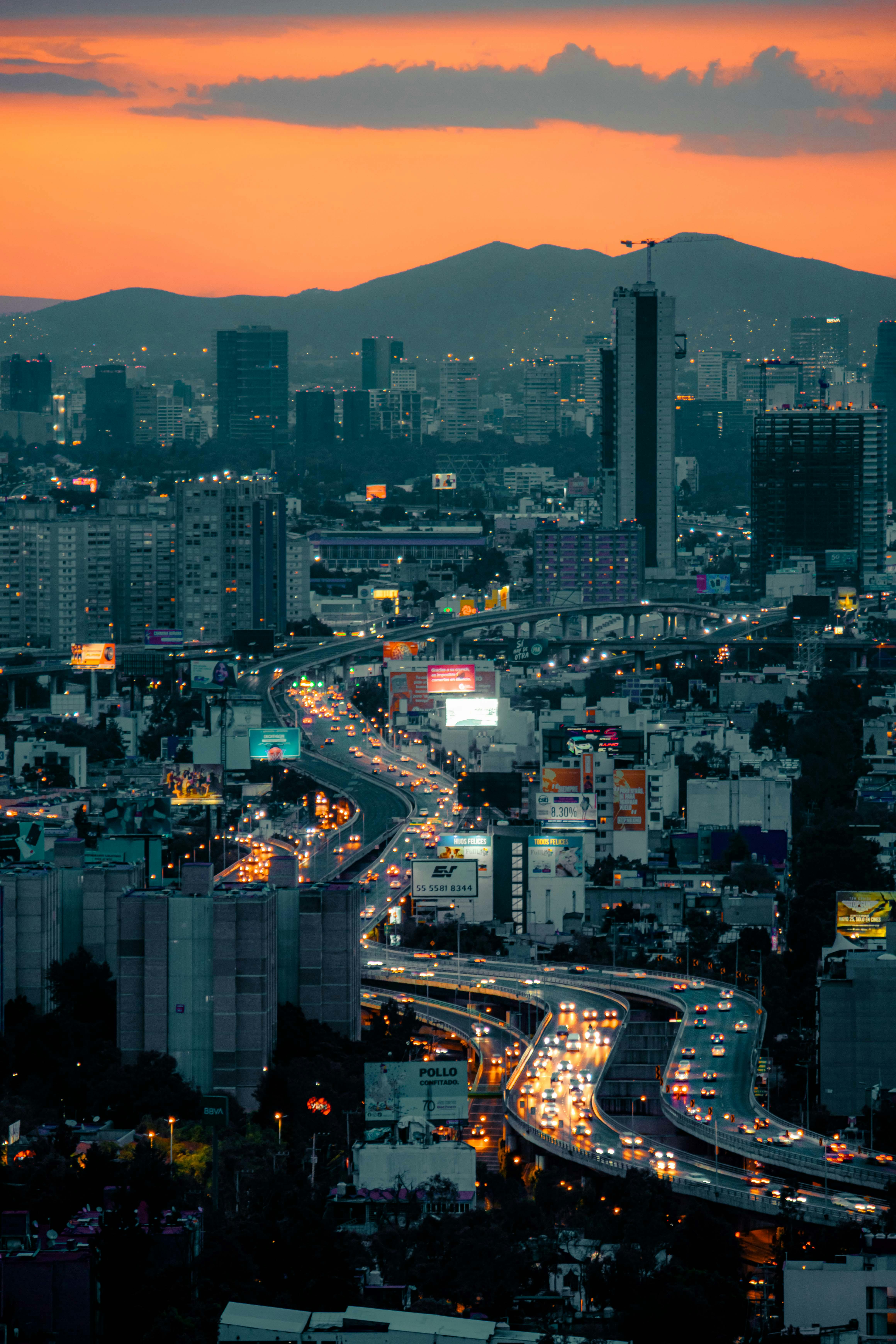 A mesmerizing view of Mexico City's illuminated skyline and bustling streets at dusk.