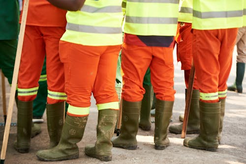 Free Group of construction workers wearing high visibility gear and boots standing outdoors. Stock Photo