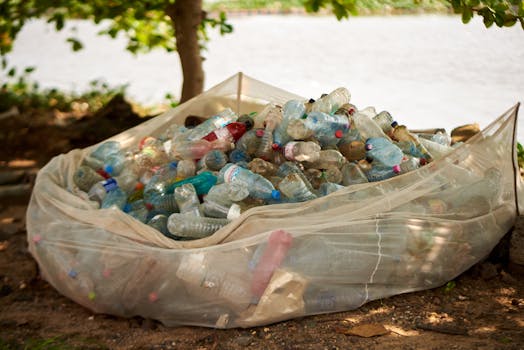 A pile of plastic bottles by a river in Douala, highlighting pollution issues.