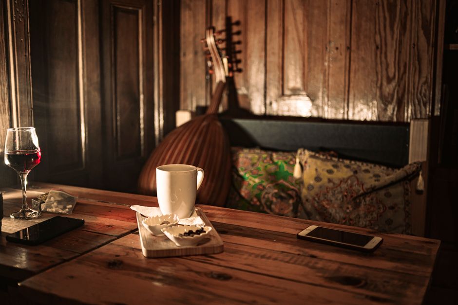 Warm interior scene with a coffee mug, wine glass, and traditional decor in Gaziantep.
