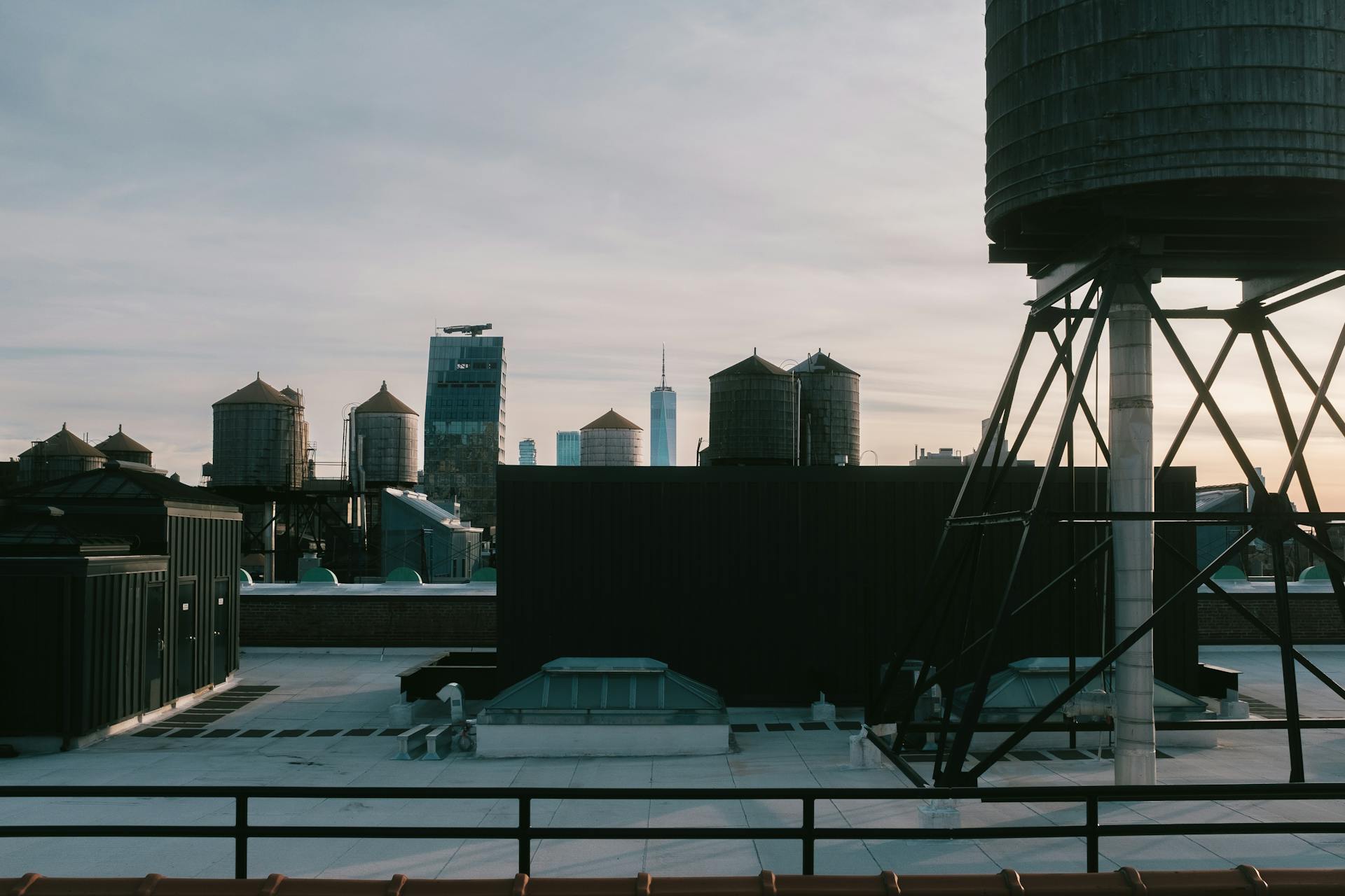 Scenic view of New York City's iconic rooftop water towers and skyline during dusk.