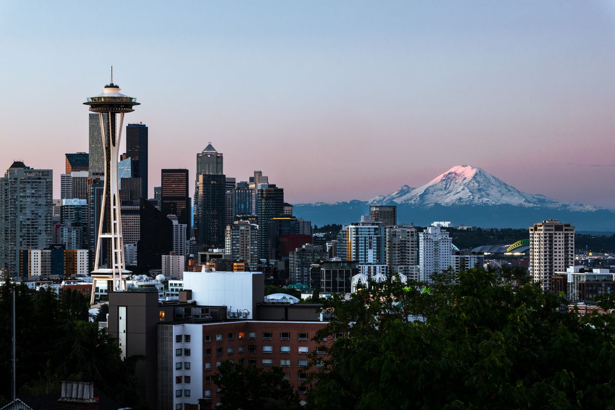 Seattle skyline with the Space Needle and Mount Rainier at dawn, the view that greets people moving to Washington State