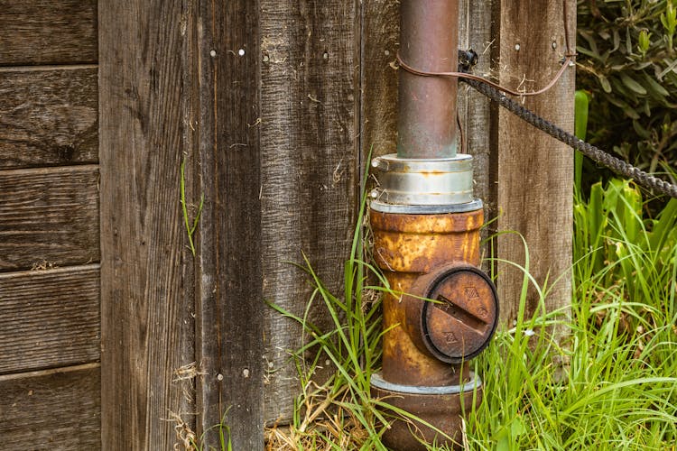 Rusty Pipe By Wooden Barn