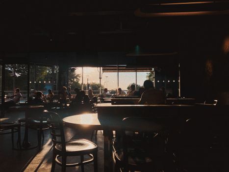 A cozy bar scene with people enjoying a relaxed atmosphere at sunset.