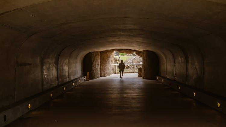 Man Walking In Empty Tunnel