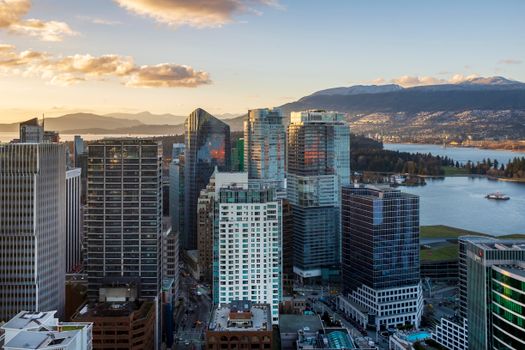 A breathtaking view of Vancouver's skyline at sunset with mountains in the backdrop.