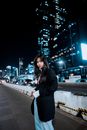 Woman in Black Coat Standing on the Road during Night Time