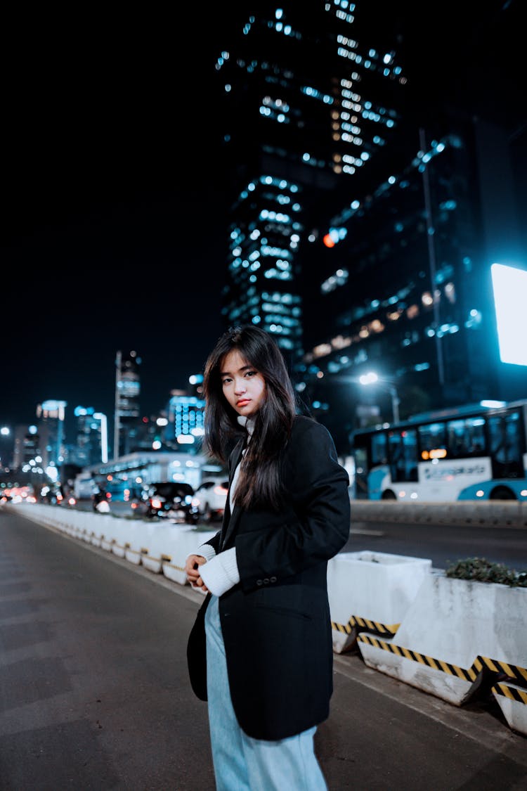 Girl With Long Black Hair Standing In City Street At Night