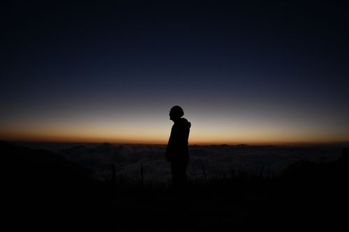 Free A man's silhouette against a twilight sky and sea of clouds at Atahualpa, Ecuador. Stock Photo
