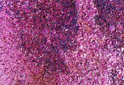 A detailed close-up of pink and purple glitter creating a sparkling abstract texture.