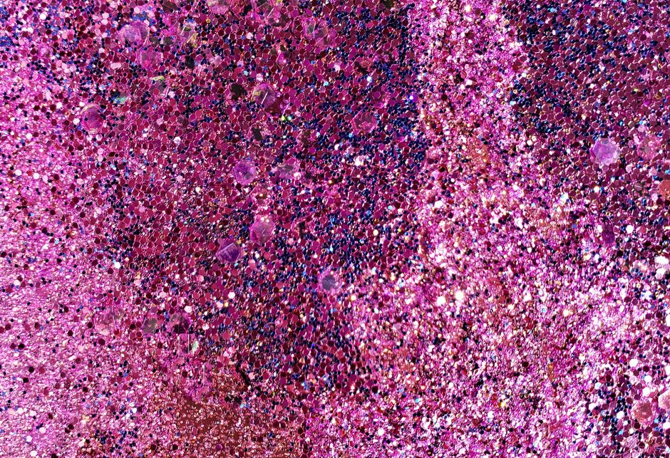 A detailed close-up of pink and purple glitter creating a sparkling abstract texture.