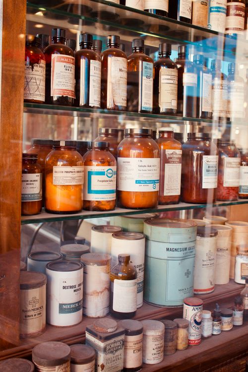 Free A collection of vintage pharmacy bottles on wooden shelves, showcasing old medicine containers. Stock Photo