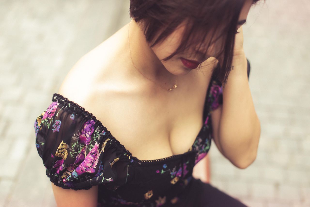 a woman in a floral dress poses elegantly outdoors creating a fashiona