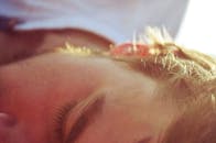 这张特写捕捉了宁静：一个男人在柔和的阳光下安睡，画面平静祥和