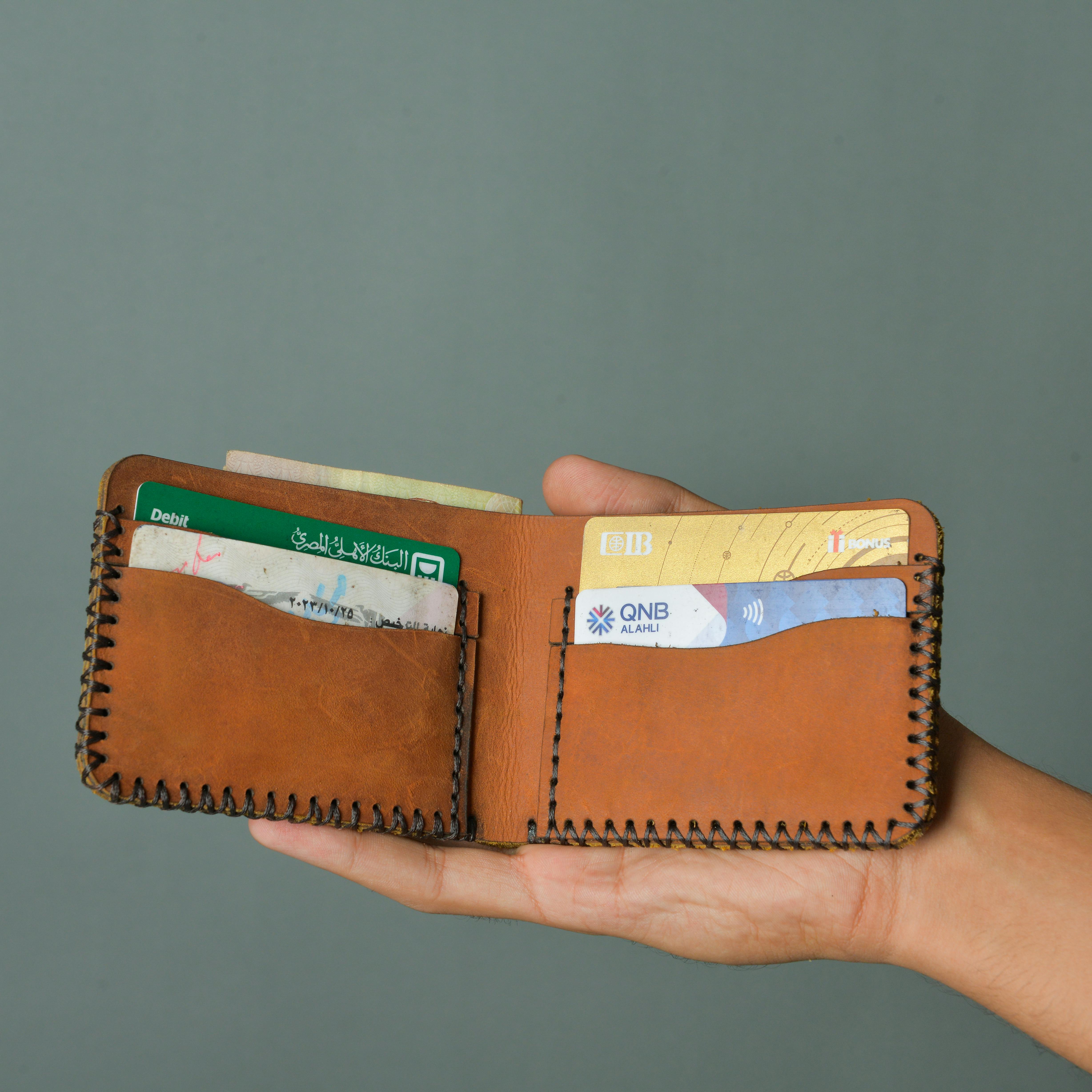 a person holding a leather wallet