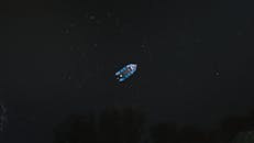 一张夜间航拍的黑暗河流上的船只照片