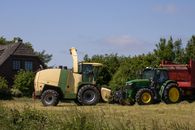Krone Big X chopper and John Deere tractor harvesting hay