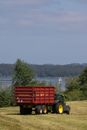 John Deere tractor pulling a trailer on meadow