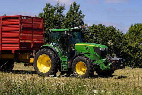 Tractor John Deere Tirando De Un Remolque En Pradera