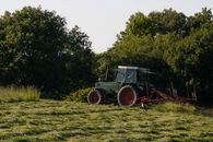 Fendt tractor turning hay on meadow
