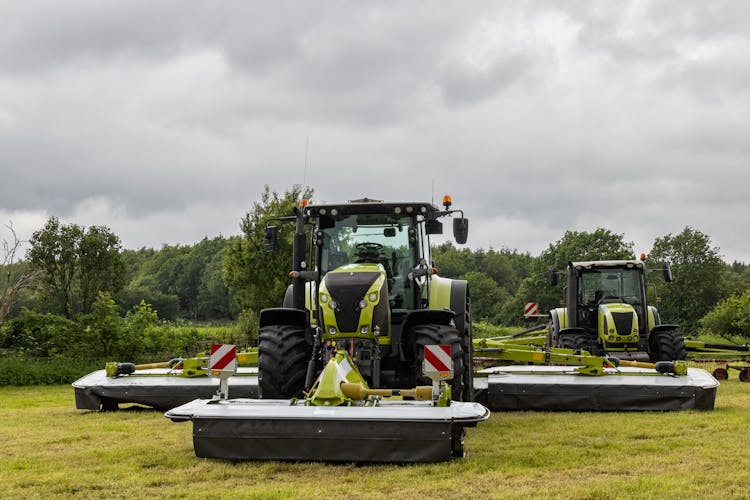 Green Tractors On Agricultural Field Under White Sky