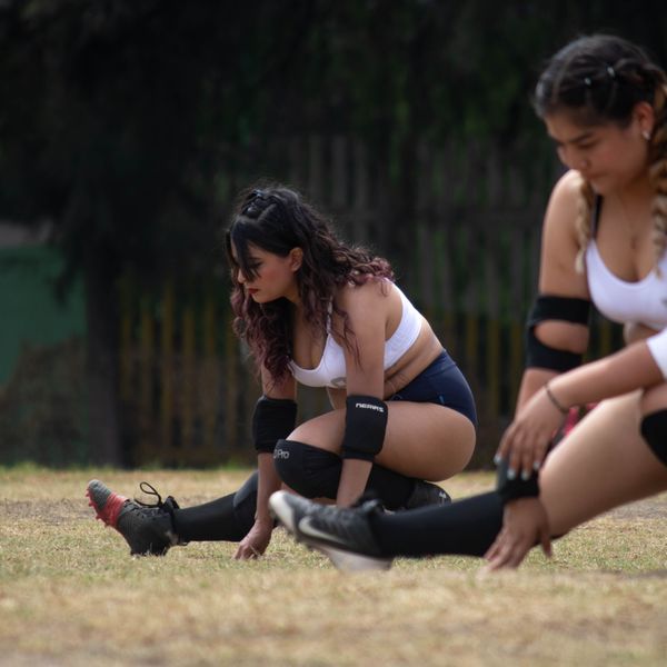 Two women stretching outdoors in activewear, photo by Kuiyibo Campos on Pexels