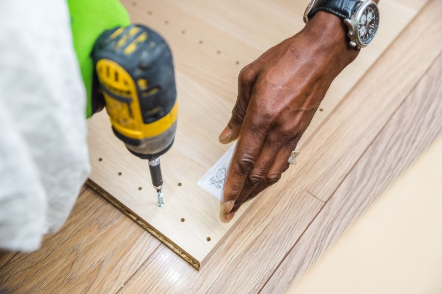 Hands using a drill during furniture assembly