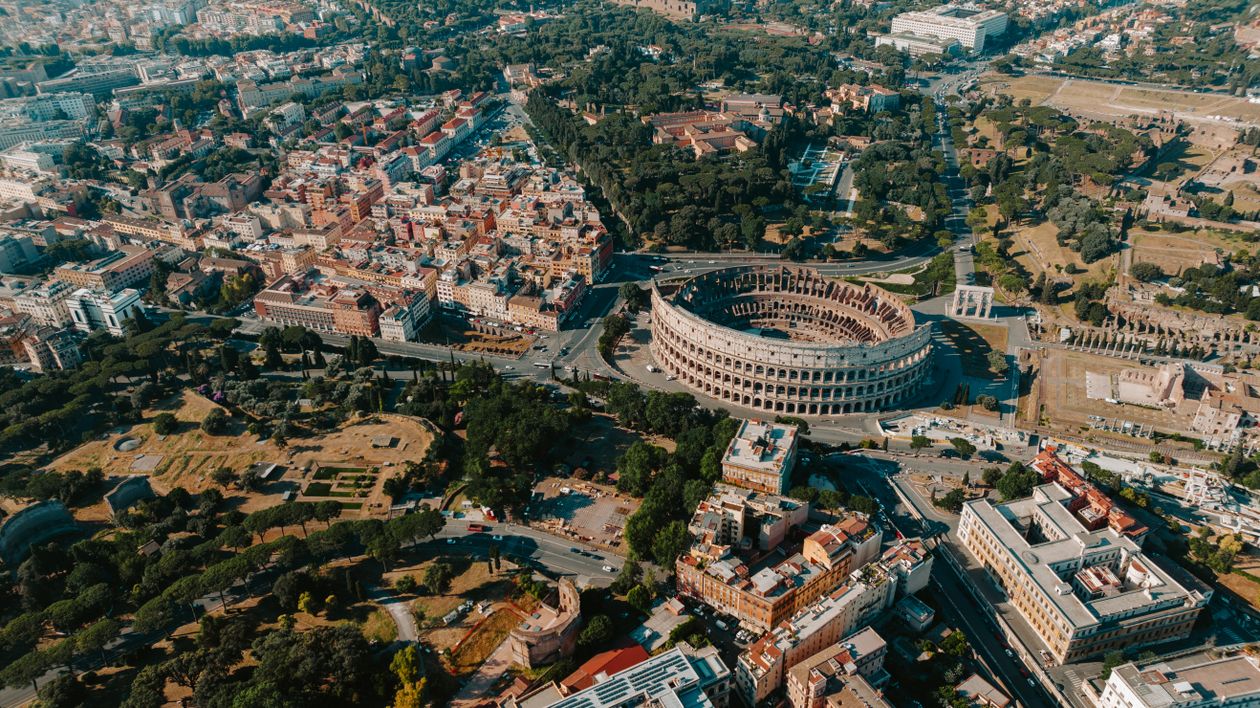 Aerial view of the Colosseum surrounded by the vibrant cityscape of Rome