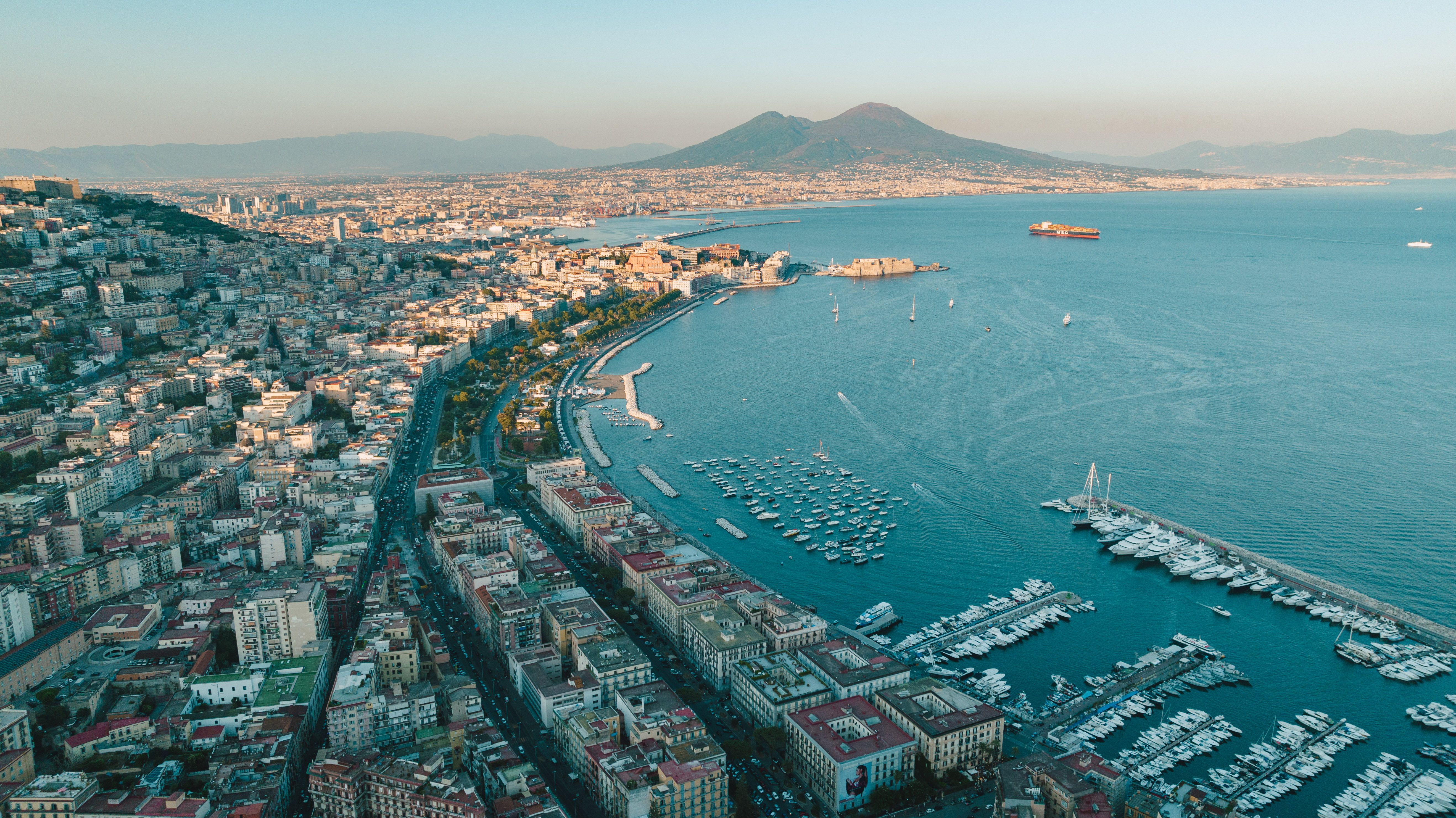 Aerial view of Naples, its marina and bay, with Mount Vesuvius rising in the distance