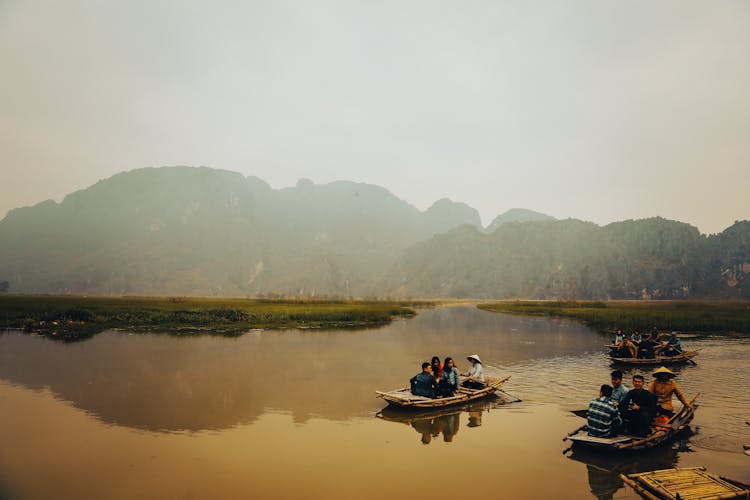 Traditional Wooden Boats With Tourists In River On Sunset