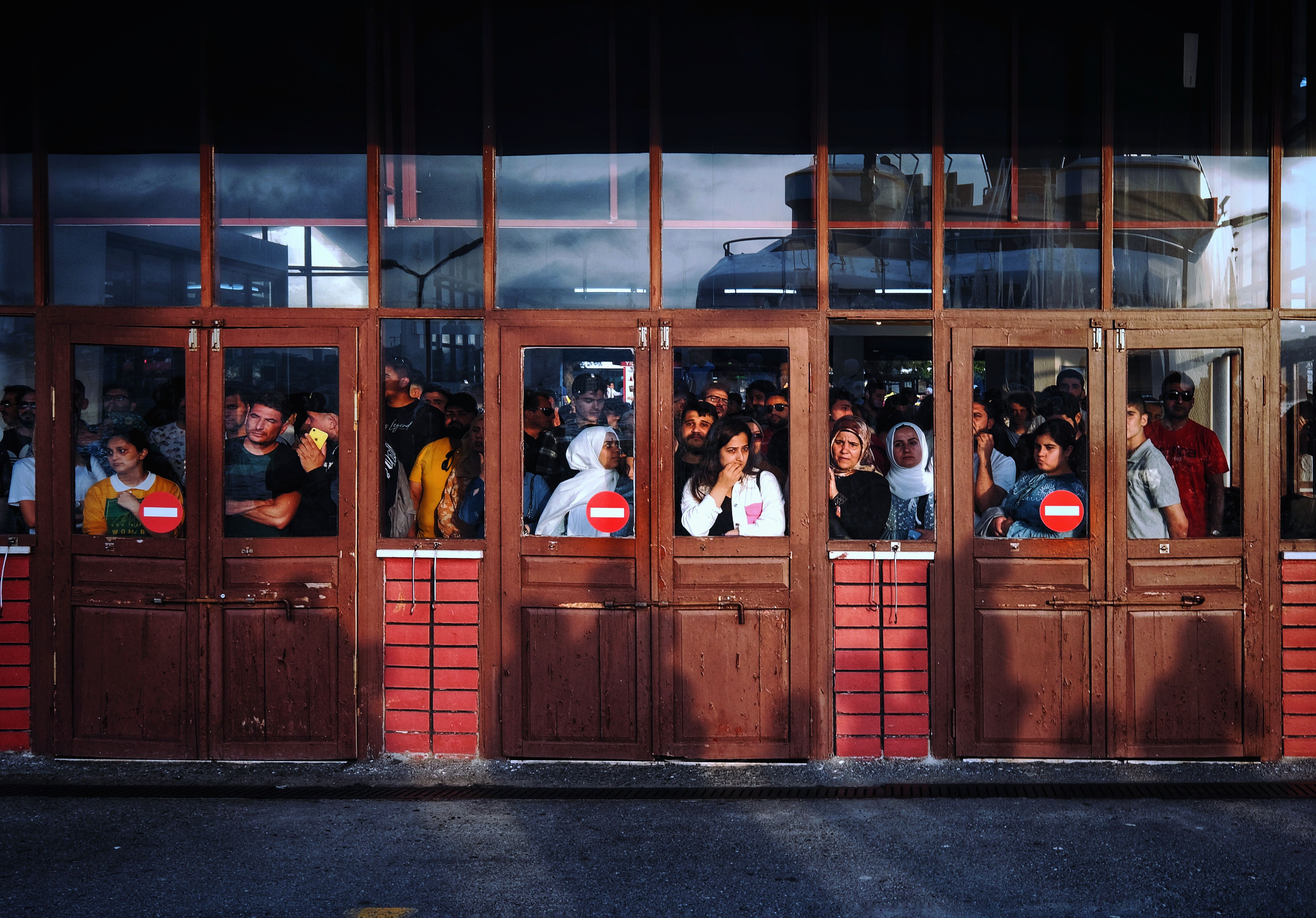 A bustling scene of people waiting inside a terminal entrance in İstanbul, Turkey.