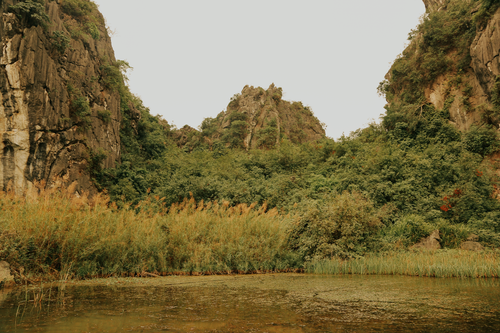 Free A calming landscape of mountains and lush greenery by a serene water body. Stock Photo
