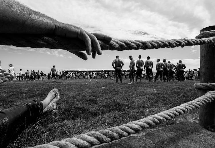 Black And White Shot Of Muscular Men At Festival