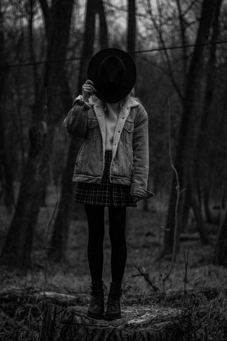 Girl Posing In Park Covering Head With Hat