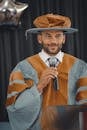 Man in Brown and Black Striped Long Sleeve Shirt Holding Black Microphone