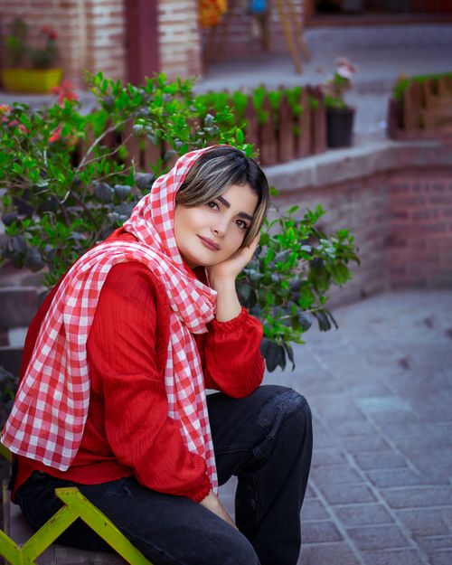 Free Fashionable woman in red attire posing thoughtfully outdoors in Iran Stock Photo