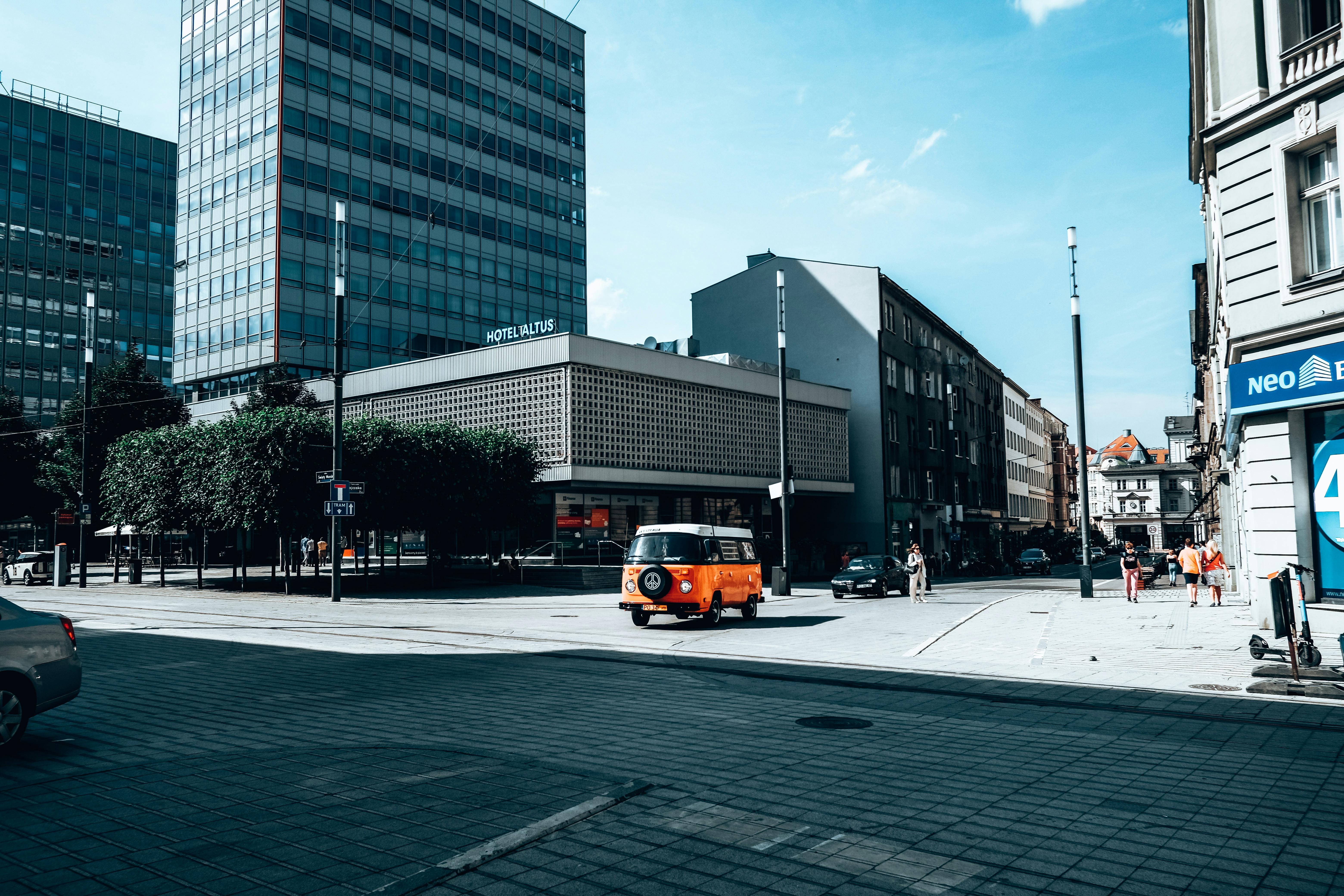 Vibrant street view in Poznan, Poland featuring a vintage van on a sunny day. - Poznan