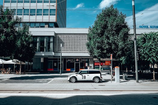 Street scene in Poznań, Poland featuring a white car and modern architecture.