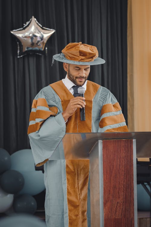 Free Man in a Graduation Gown Giving a Speech Stock Photo