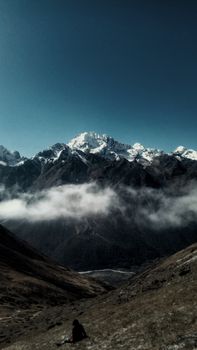 Stunning view of snowcapped mountains in Langtang, Nepal with dramatic clouds.