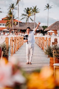 Photographer capturing moments on a stunning tropical beach pier during summer.
