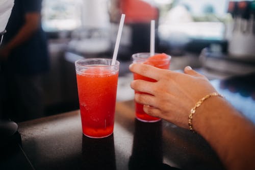 A Person Holding Icee Drinks
